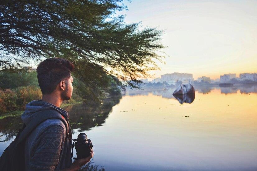 man-holding-camera-while-standing-by-lake-against-sky-sunset_1048944-7349256.jpg