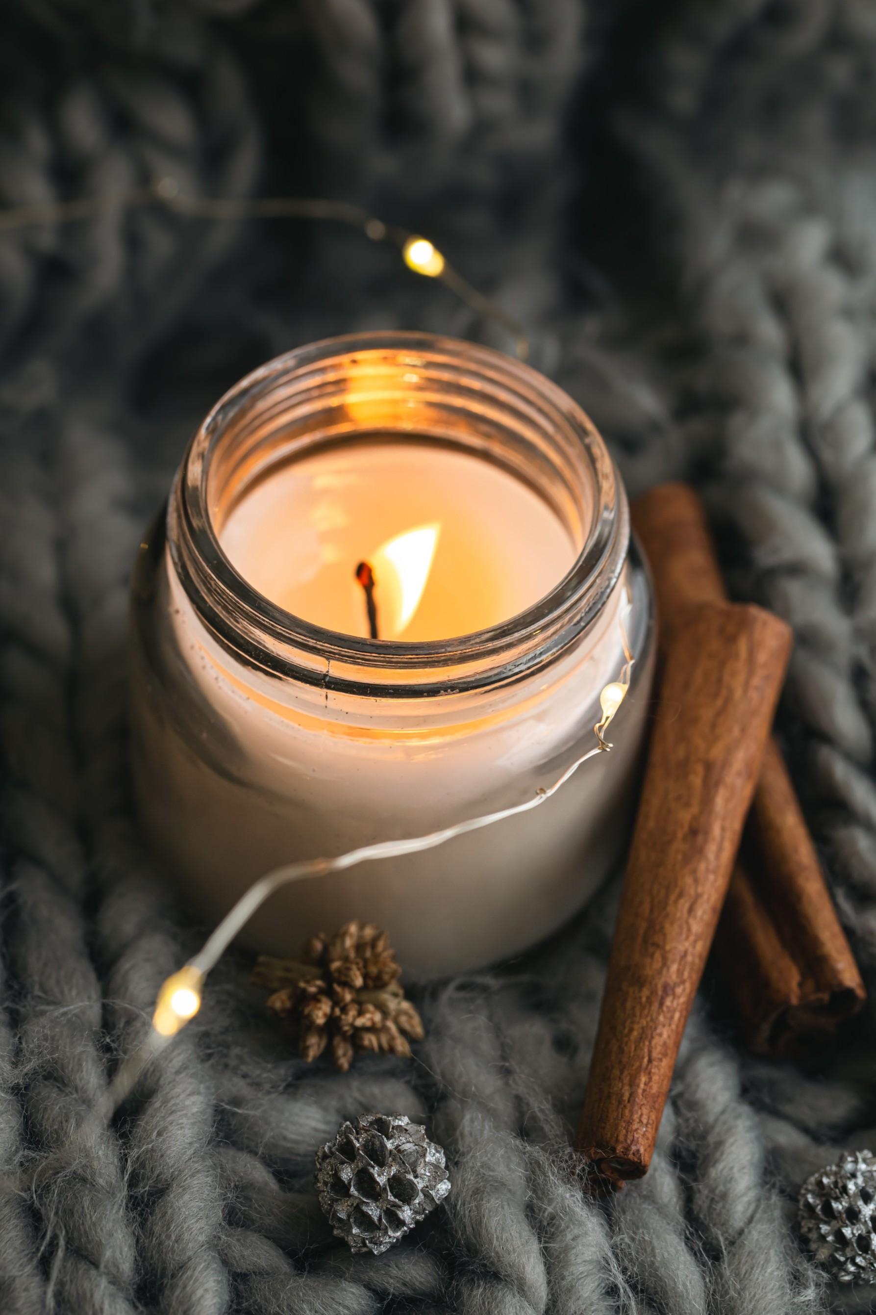 closeup-candle-cinnamon-sticks-background-gray-knitted-element (1) (1).jpg