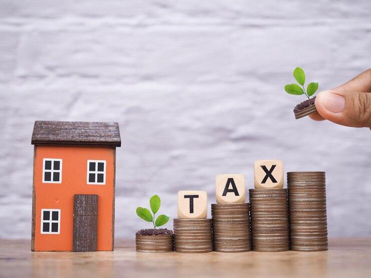 miniature-house-wooden-blocks-with-word-tax-stack-coins-concept-payment-tax-house-property-investment-house-mortgage-real-estate_42299-2869.jpg