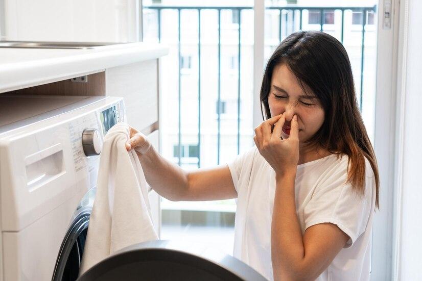 young-asian-woman-looking-dirty-smelly-clothe-out-washing-machine-kitchen_1048944-22558237.jpg