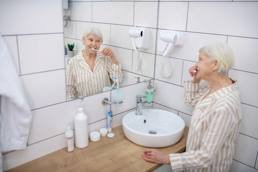 morning-routine-elderly-woman-brushing-her-teeth-bathroom_259150-12196.jpg